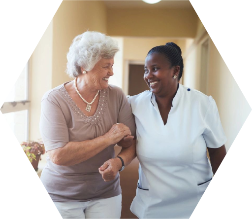 A nurse and an older woman are smiling together.